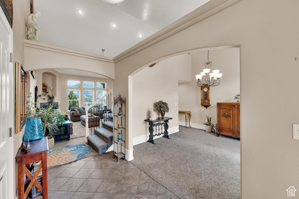 Foyer featuring a high ceiling, arched walkways, recessed lighting, and a chandelier