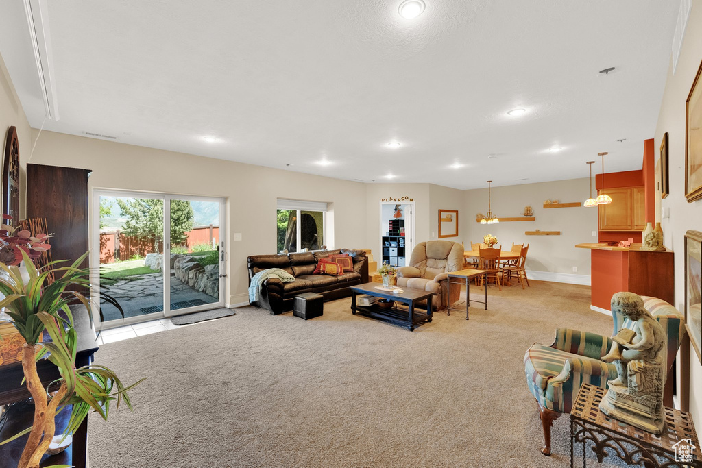 Living area with light carpet and recessed lighting