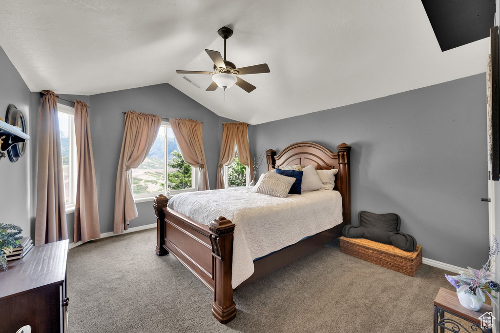 Carpeted bedroom featuring lofted ceiling and a ceiling fan
