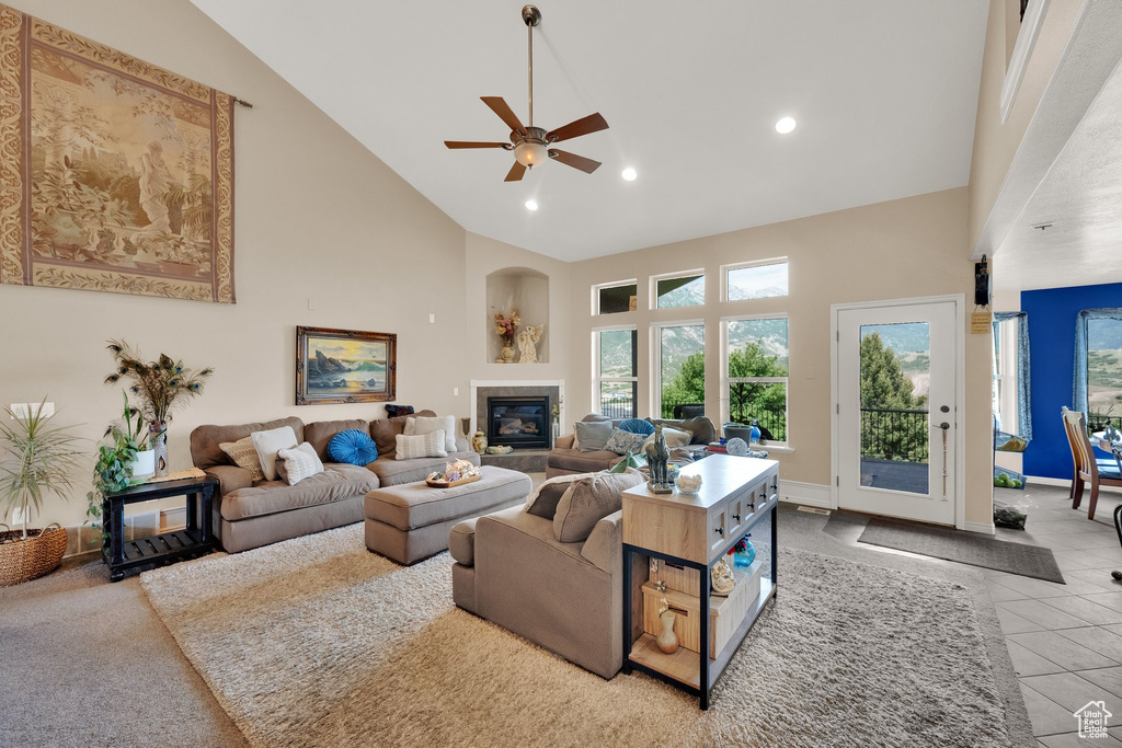 Tiled living area featuring high vaulted ceiling, recessed lighting, healthy amount of natural light, a ceiling fan, and a tiled fireplace