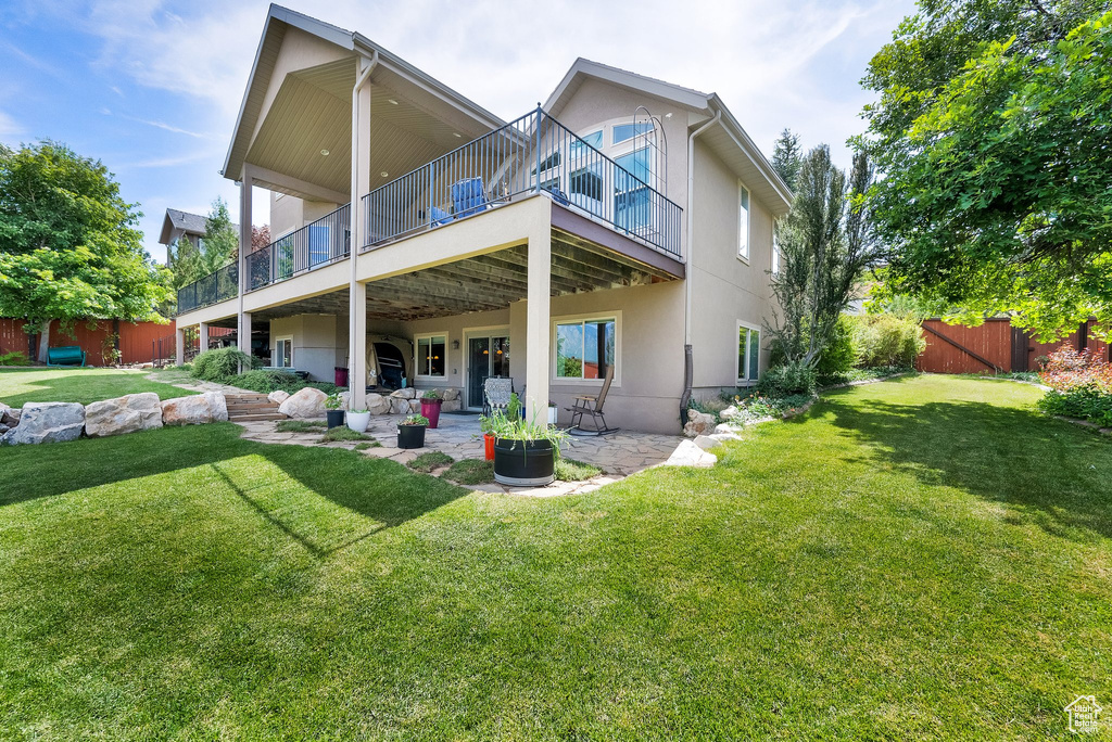 Back of house featuring stucco siding, a patio, and a balcony