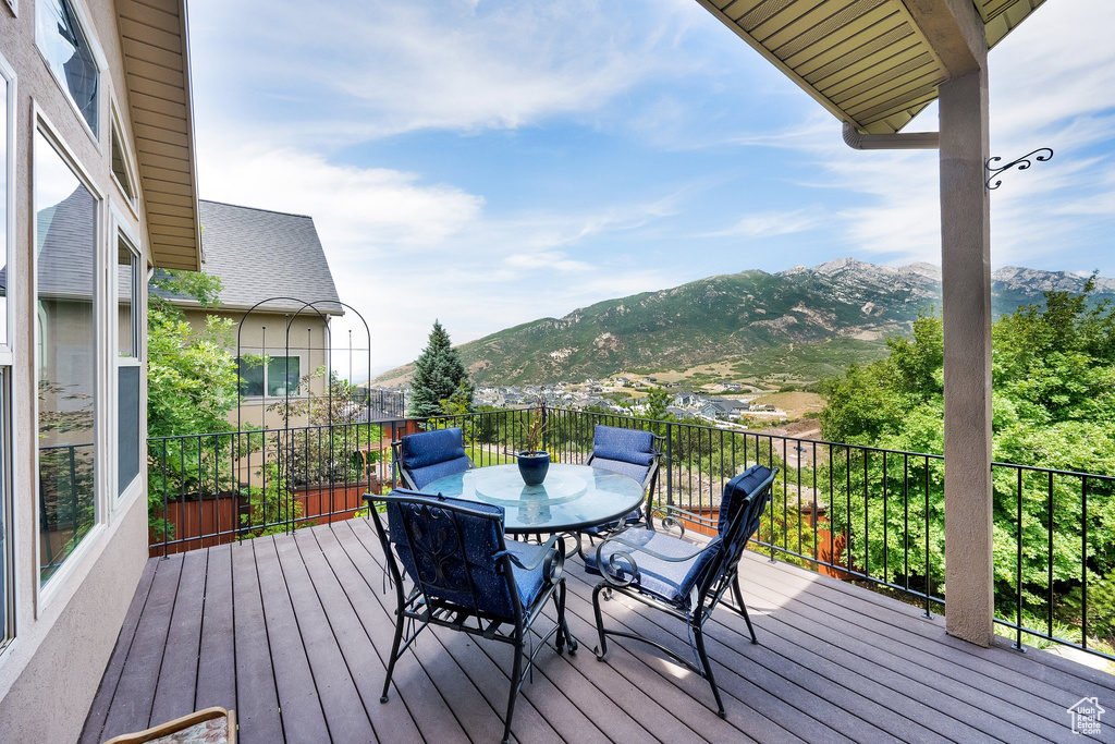 Wooden terrace featuring a mountain view and outdoor dining space