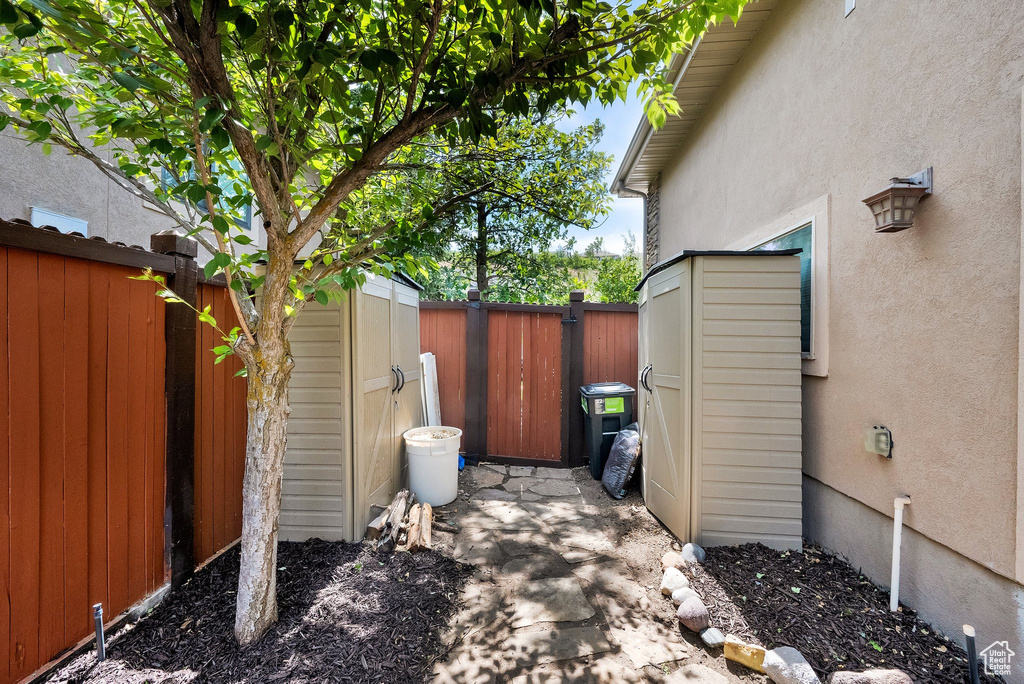 Fenced backyard featuring a storage shed