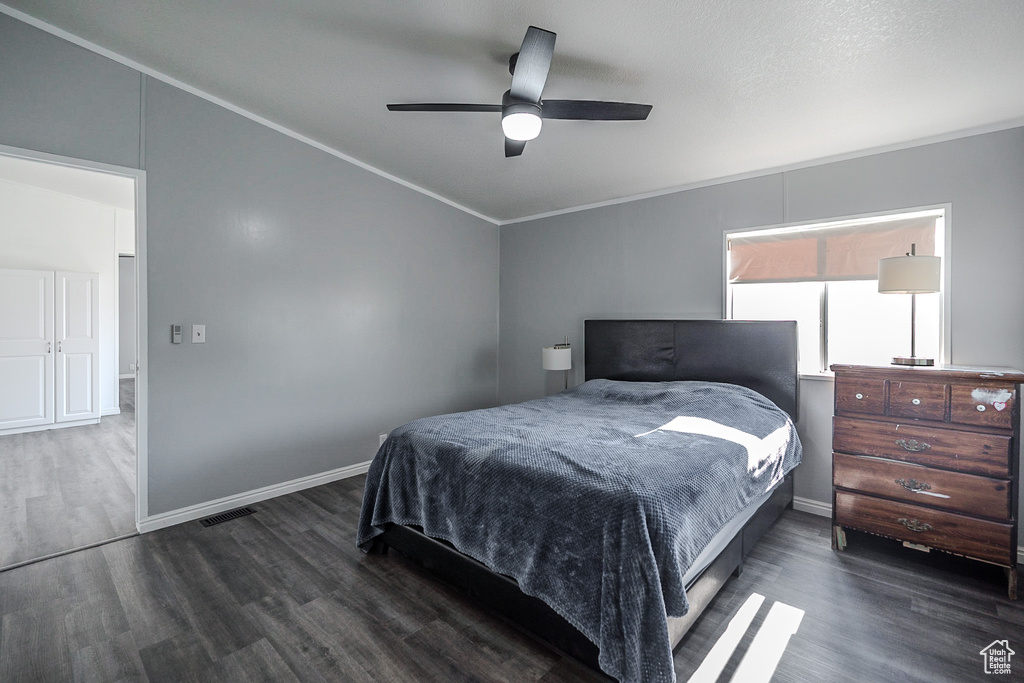 Bedroom featuring wood finished floors, crown molding, and a ceiling fan