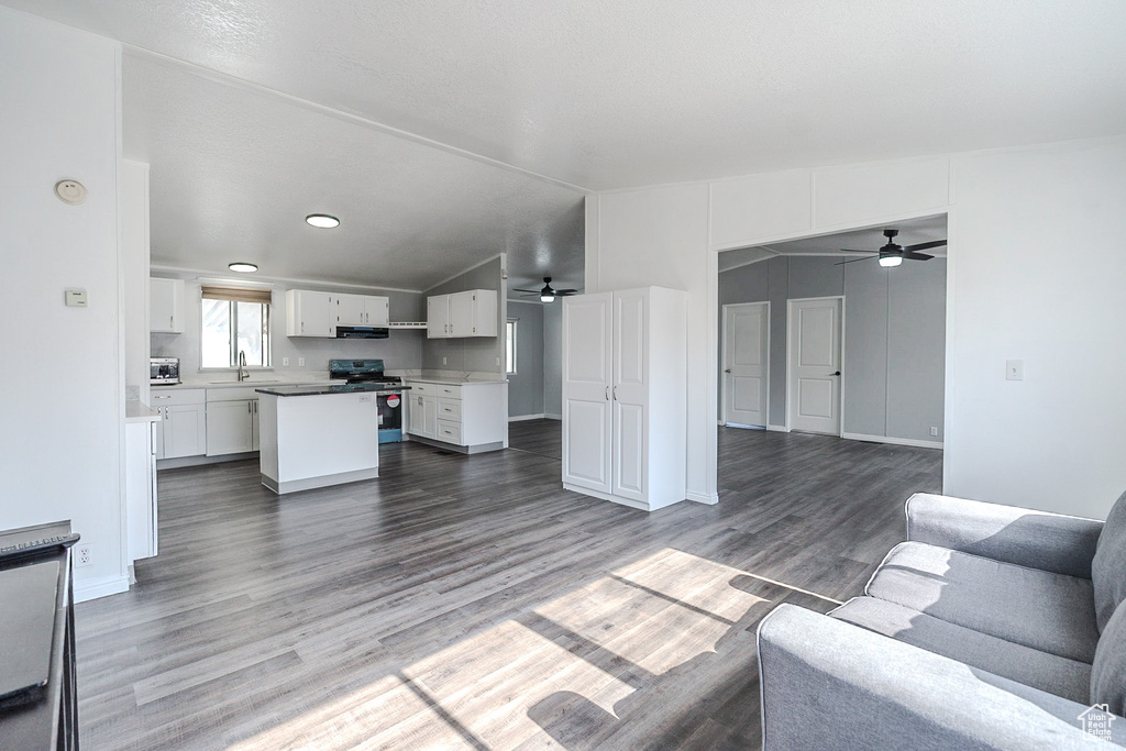 Living area featuring ceiling fan, wood finished floors, vaulted ceiling, and recessed lighting