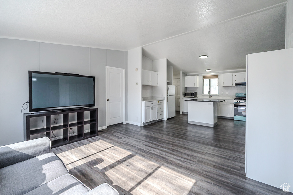Unfurnished living room with dark wood-type flooring and lofted ceiling