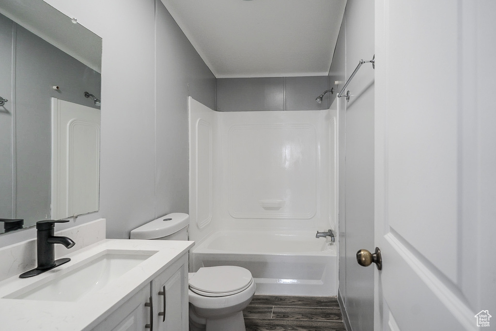 Full bath featuring wood finished floors, vanity, and tub / shower combination