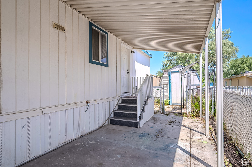 View of patio featuring a shed and an attached carport