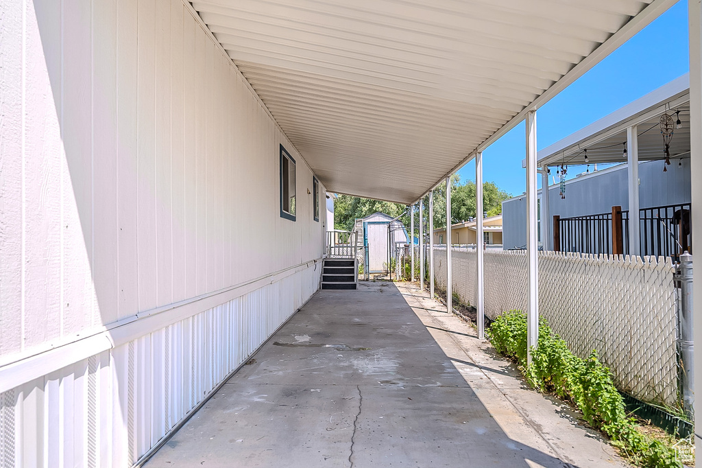 View of patio featuring a storage unit and a carport