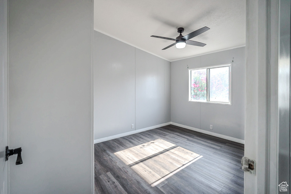 Unfurnished room with ornamental molding, wood finished floors, and a ceiling fan