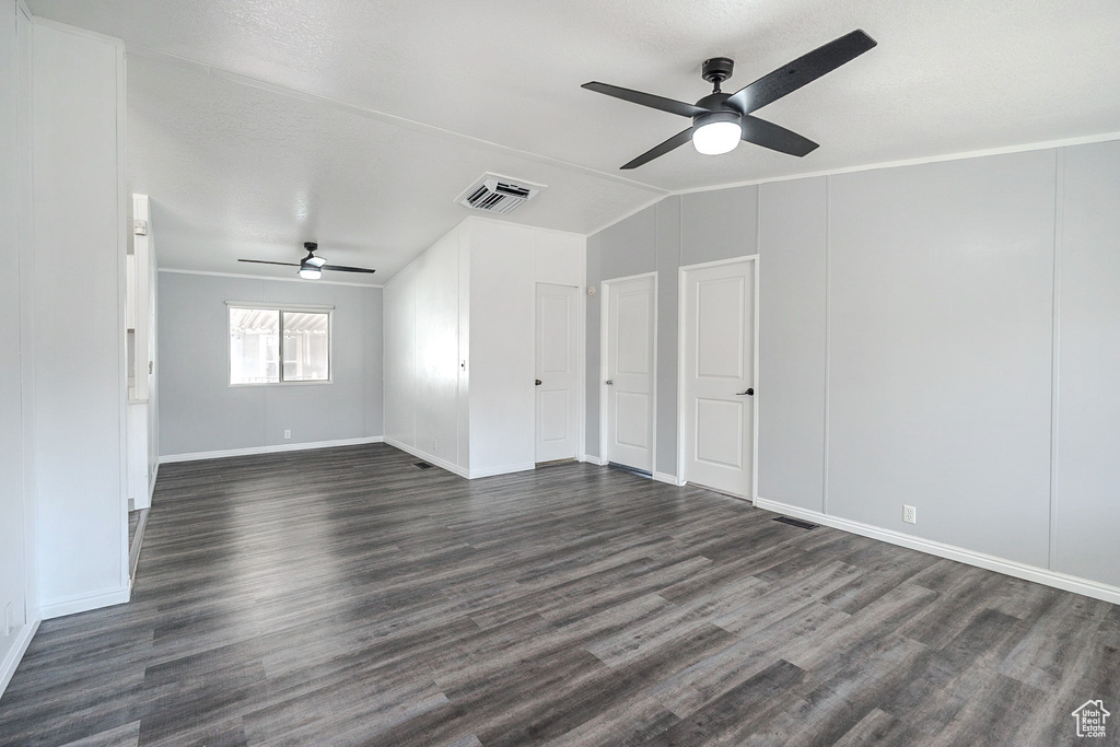 Unfurnished room with ceiling fan, dark wood-type flooring, and lofted ceiling