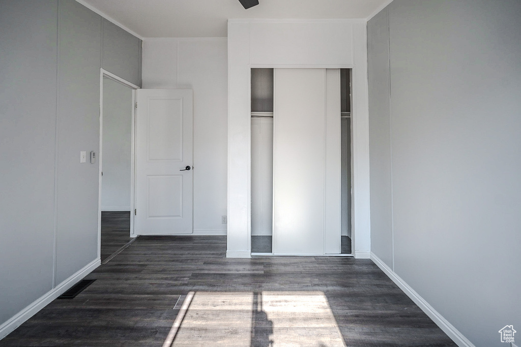 Unfurnished bedroom with wood finished floors and a closet