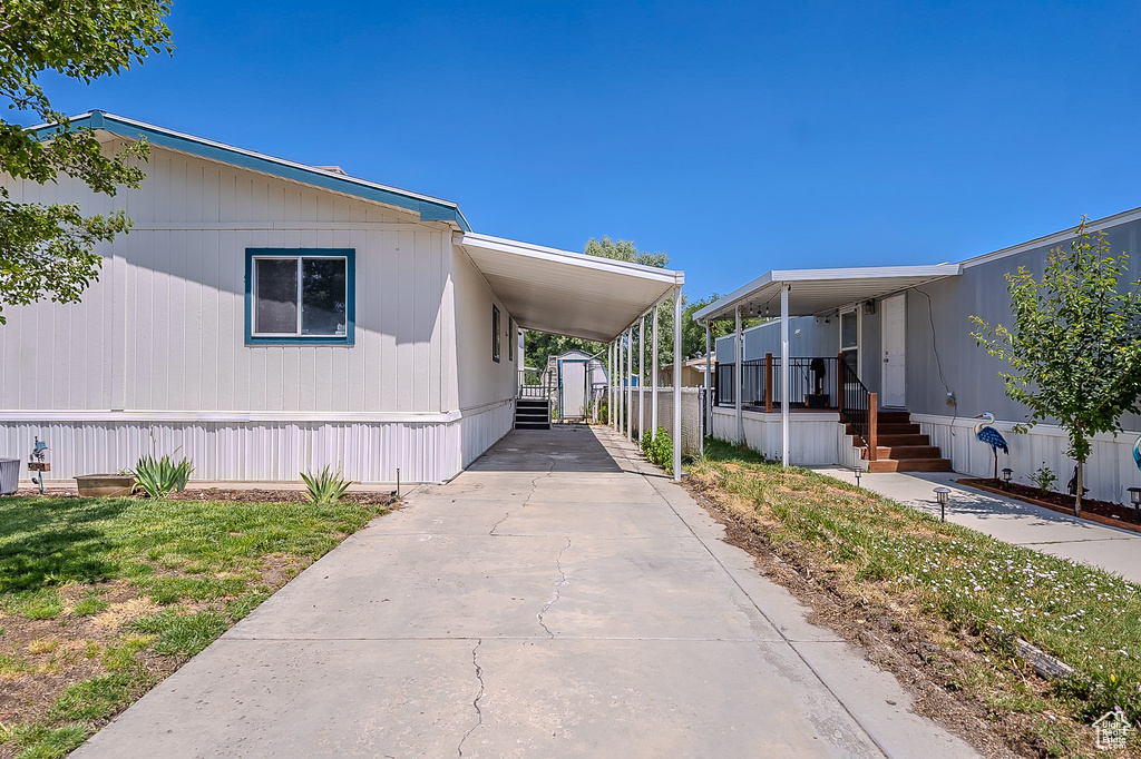 View of side of home with a shed, driveway, and an attached carport
