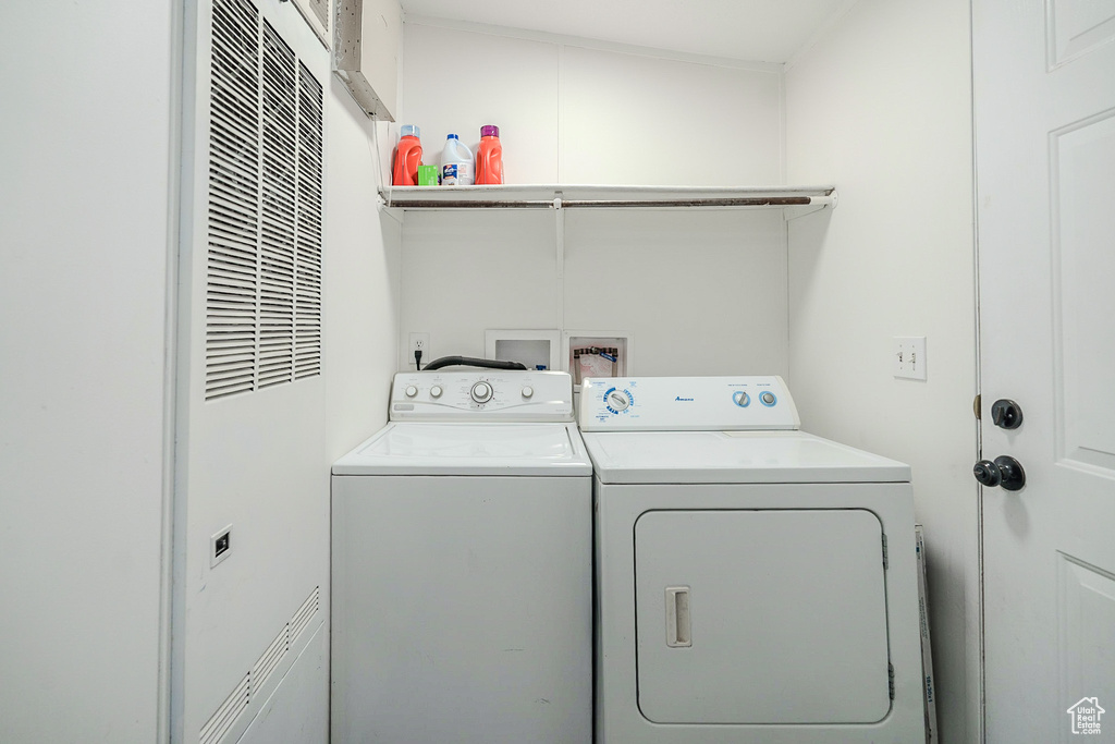 Laundry room with a heating unit and washing machine and dryer