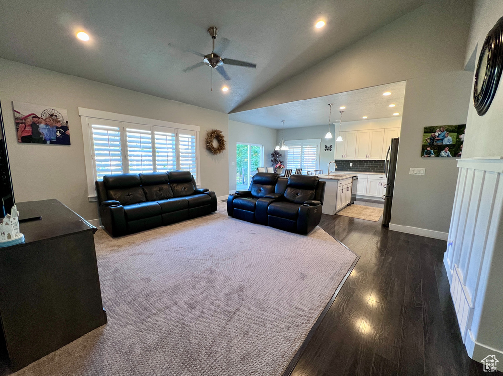 Living area featuring a ceiling fan, vaulted ceiling, recessed lighting, and dark wood-style floors