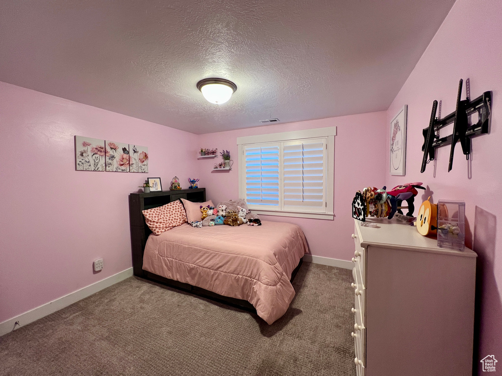 Bedroom with a textured ceiling and carpet