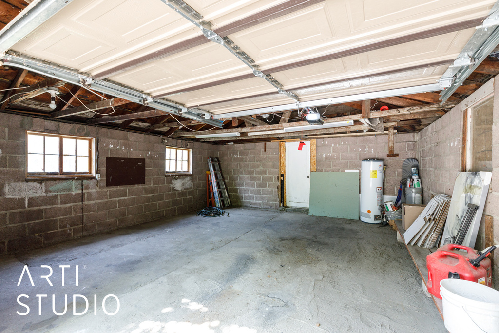 Garage featuring water heater and concrete block wall