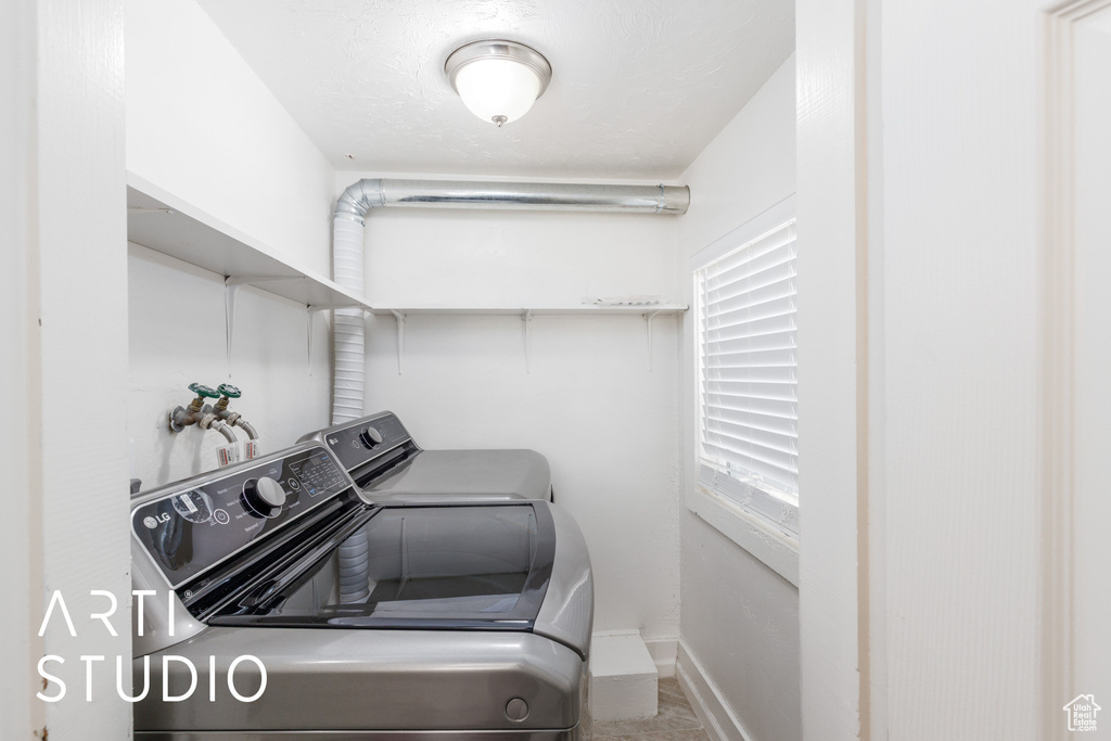 Washroom featuring separate washer and dryer and baseboards