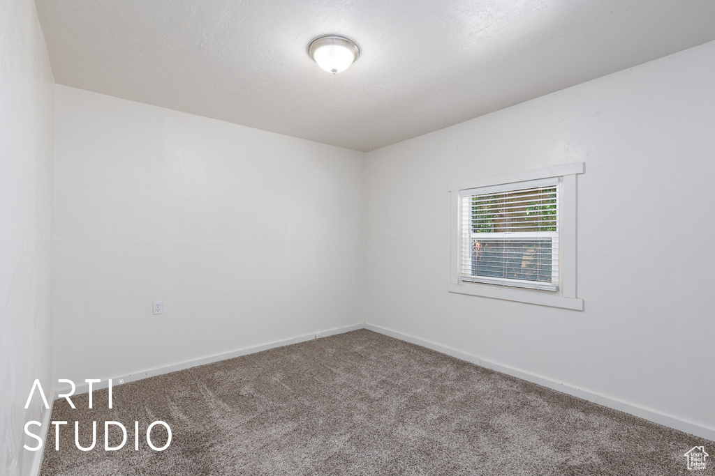 Unfurnished room featuring carpet and baseboards