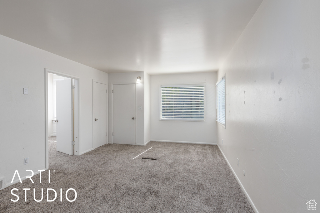 Unfurnished bedroom with carpet flooring and ensuite bathroom