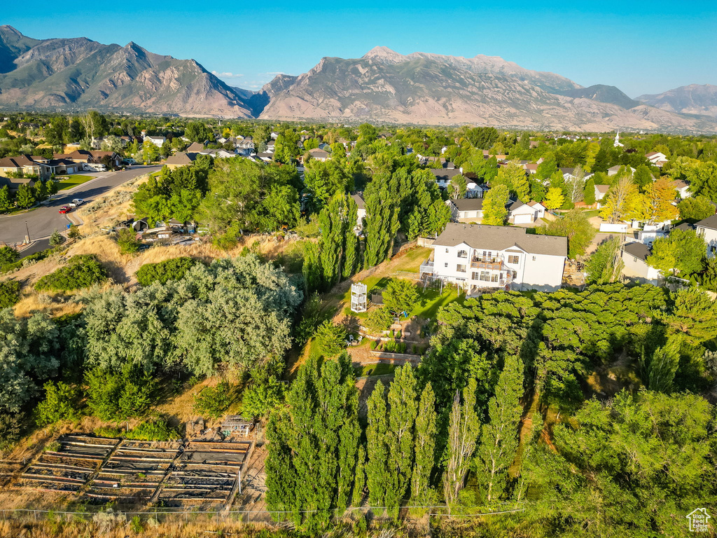 Aerial view of property and surrounding area with mountains and nearby suburban area
