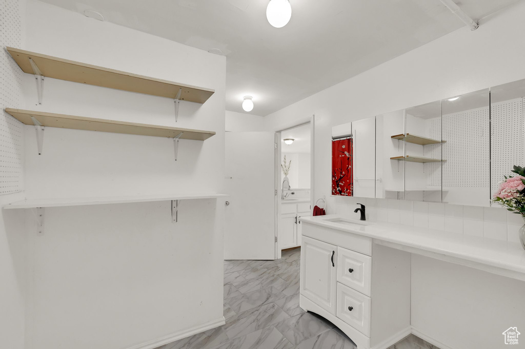 Kitchen featuring open shelves, light marble finish flooring, white cabinets, and light countertops