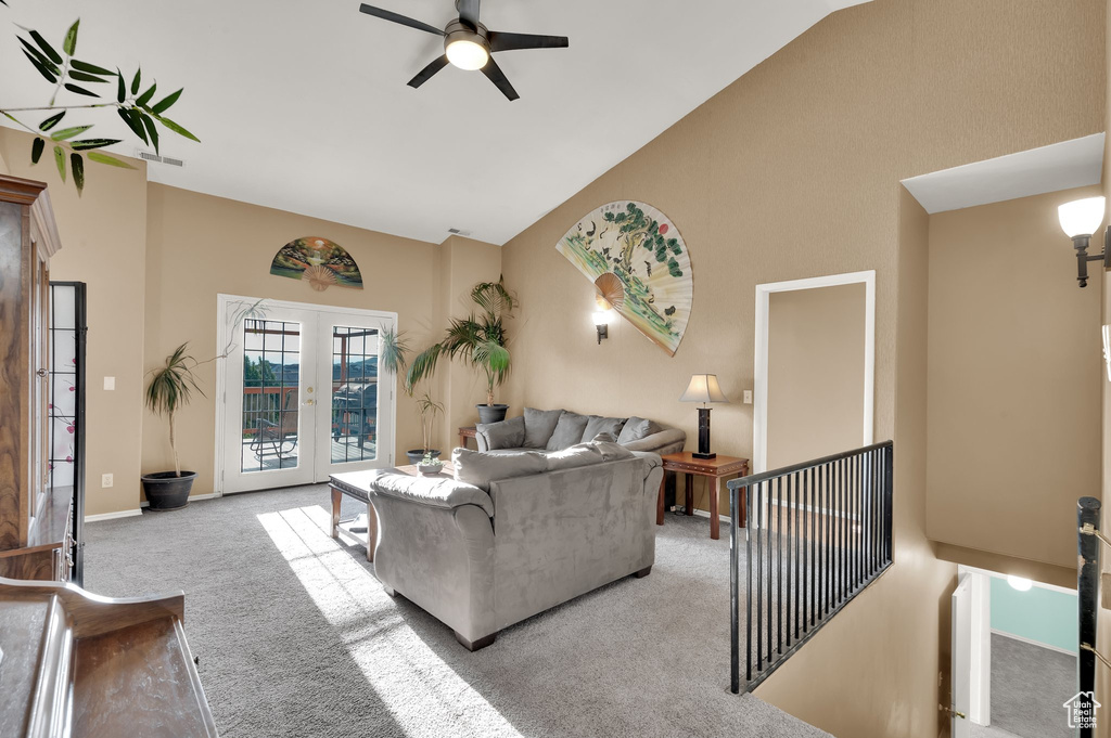 Living area featuring high vaulted ceiling, light carpet, a ceiling fan, and french doors