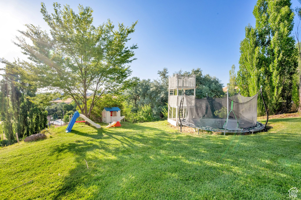 View of green lawn featuring a trampoline