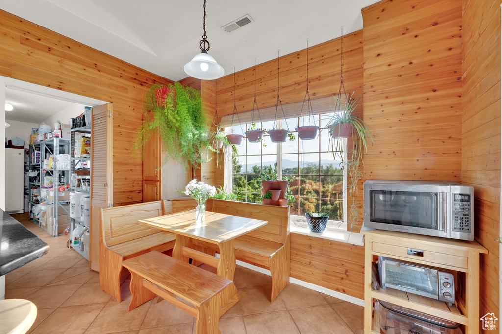Dining room featuring wood walls and light tile patterned floors