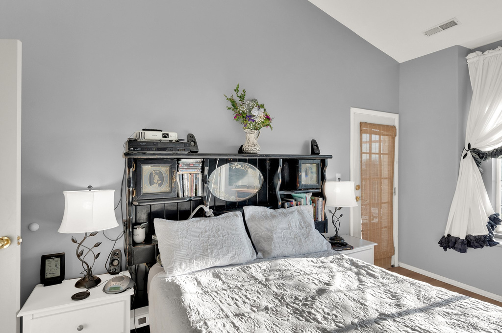 Bedroom with vaulted ceiling and baseboards