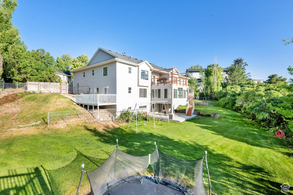 Back of house featuring stairs, a patio area, and a wooden deck