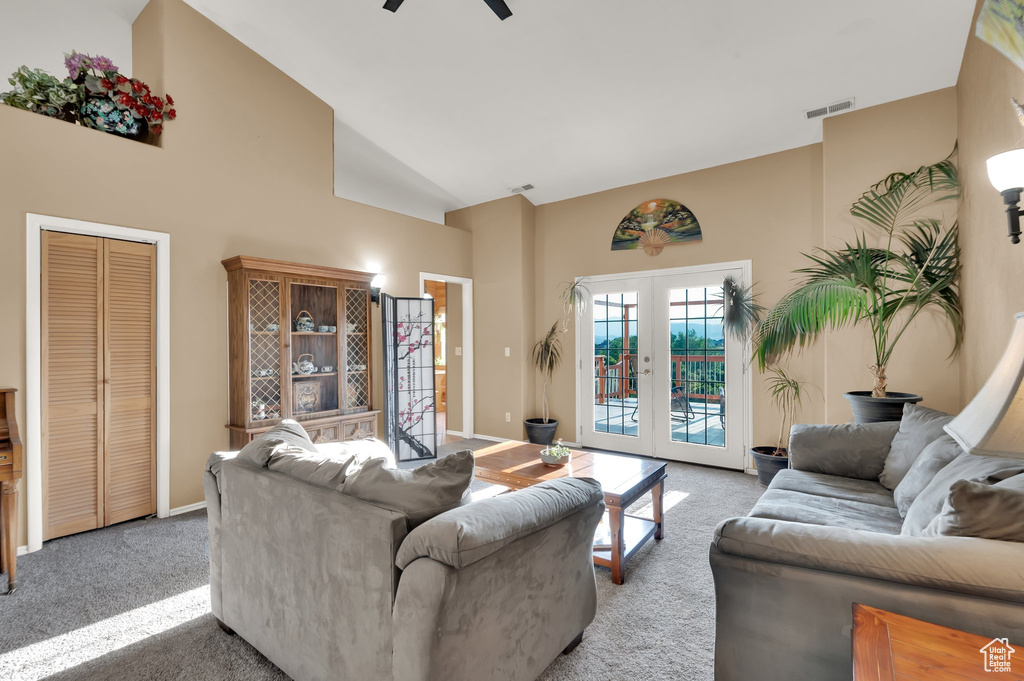Living area featuring high vaulted ceiling, light colored carpet, a ceiling fan, and french doors
