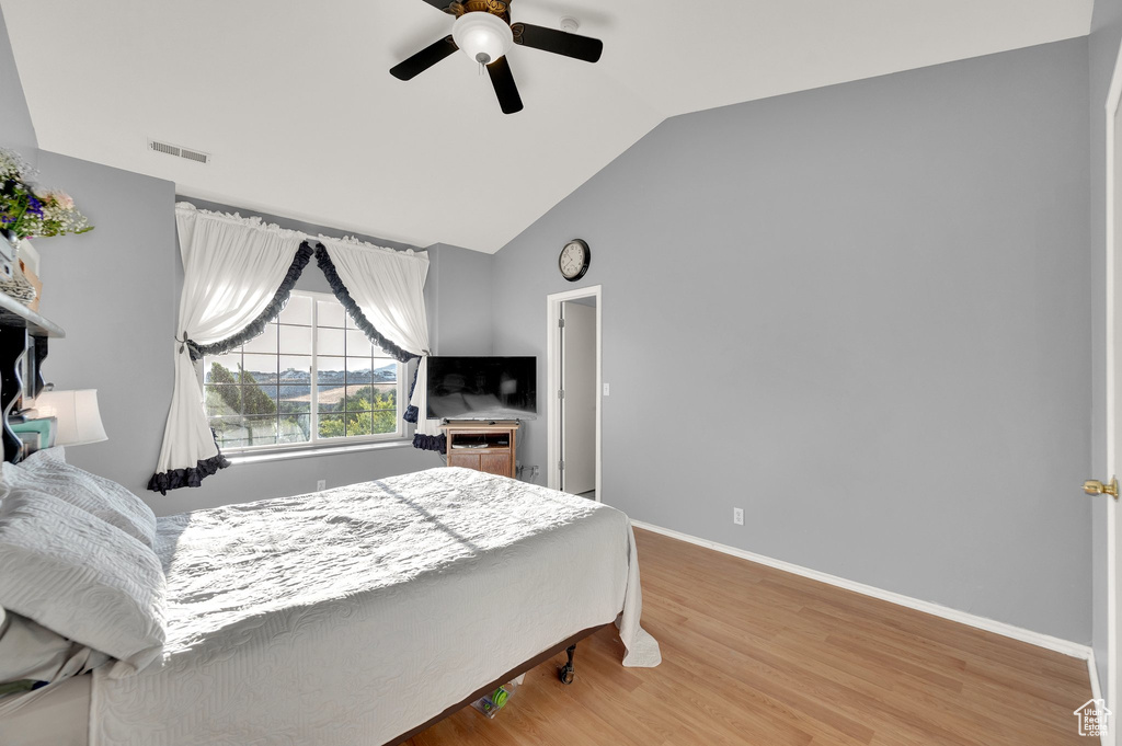 Bedroom with lofted ceiling, light wood-style flooring, and a ceiling fan