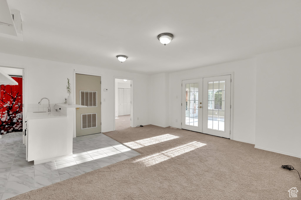 Unfurnished room with french doors and light colored carpet