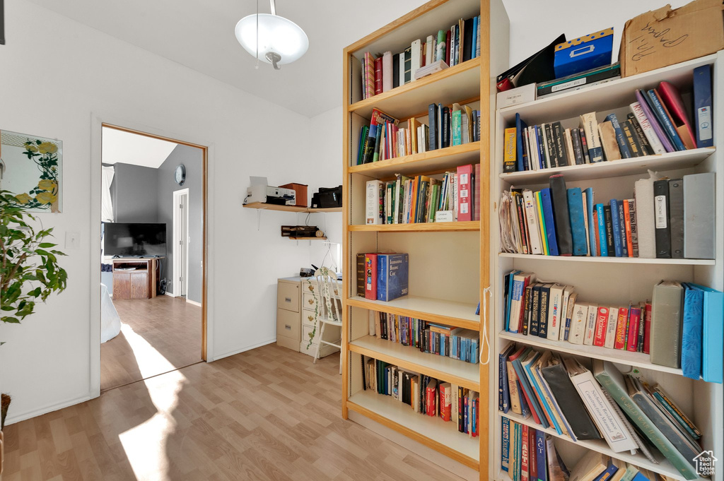 Living area with wood finished floors and wall of books