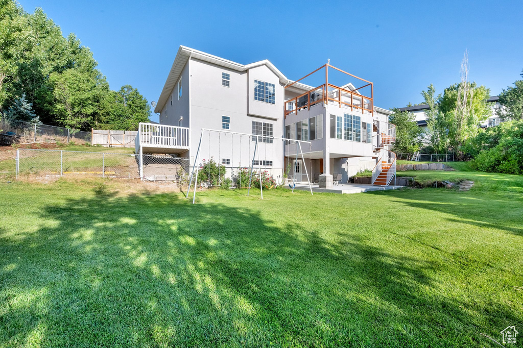 Rear view of property with a patio, a wooden deck, and stairs