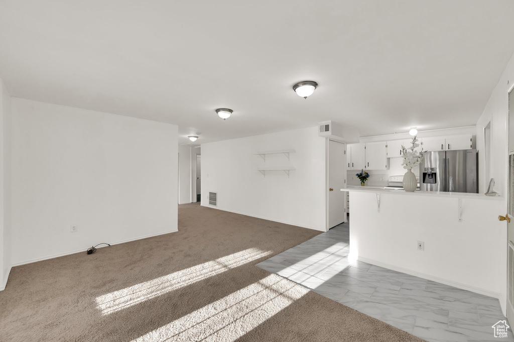 Unfurnished living room with light marble finish floors
