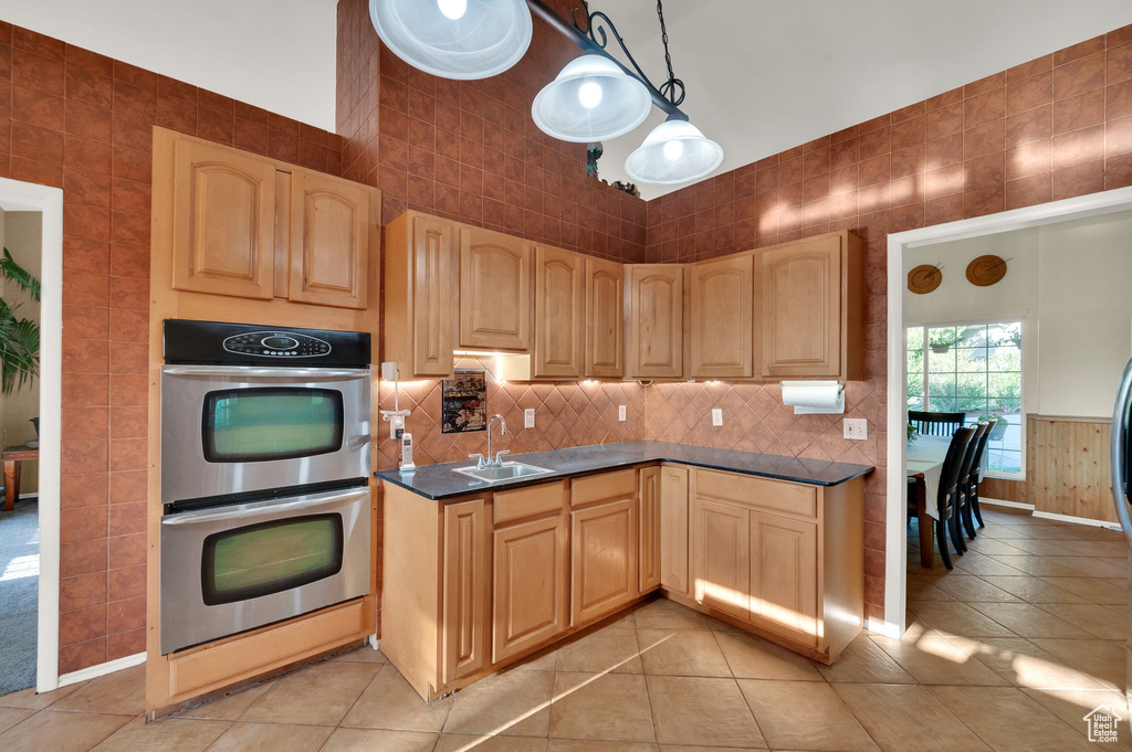 Kitchen featuring stainless steel double oven, dark countertops, and light tile patterned floors
