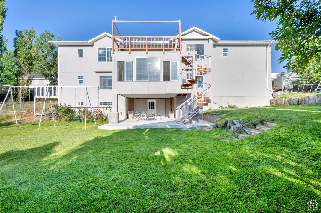 Back of house with stairway, a patio area, a deck, and stucco siding