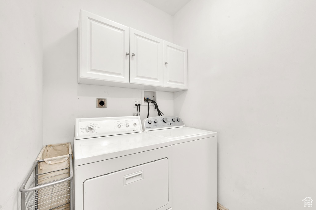 Laundry area with cabinet space and washing machine and clothes dryer