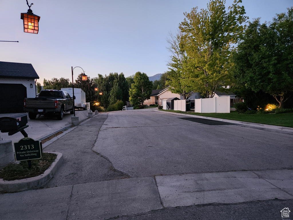 View of asphalt road with street lights and curbs