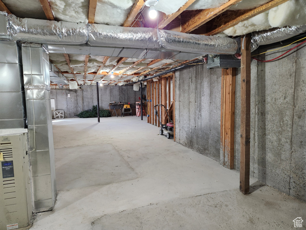Unfinished below grade area featuring heating unit