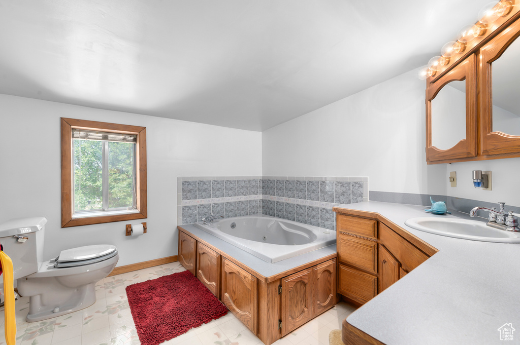 Bathroom featuring vanity and a tub with jets