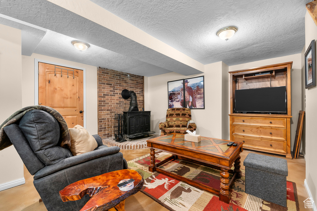 Living area featuring a wood stove and a textured ceiling