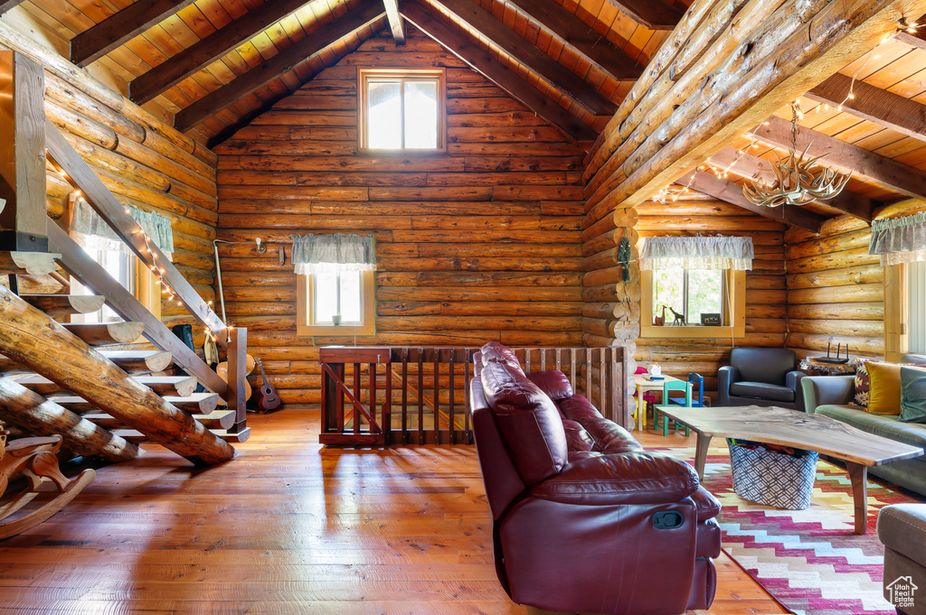Living room with wood ceiling, plenty of natural light, wood-type flooring, and rustic walls