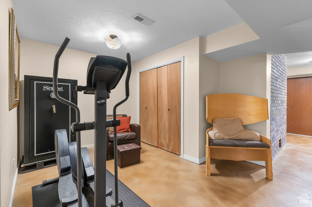 Workout room featuring a textured ceiling and baseboards