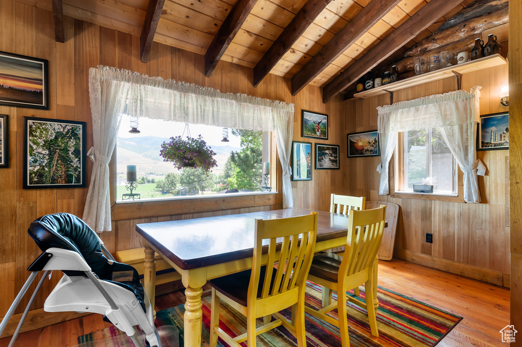 Dining area with wooden walls, wood ceiling, and wood-type flooring