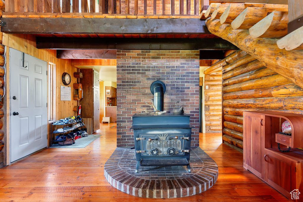 Detailed view of a wood stove, wood finished floors, rustic walls, and wood walls