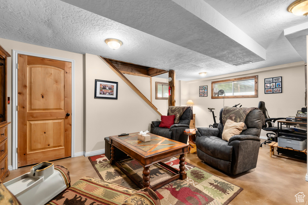 Living room featuring a textured ceiling and finished concrete flooring
