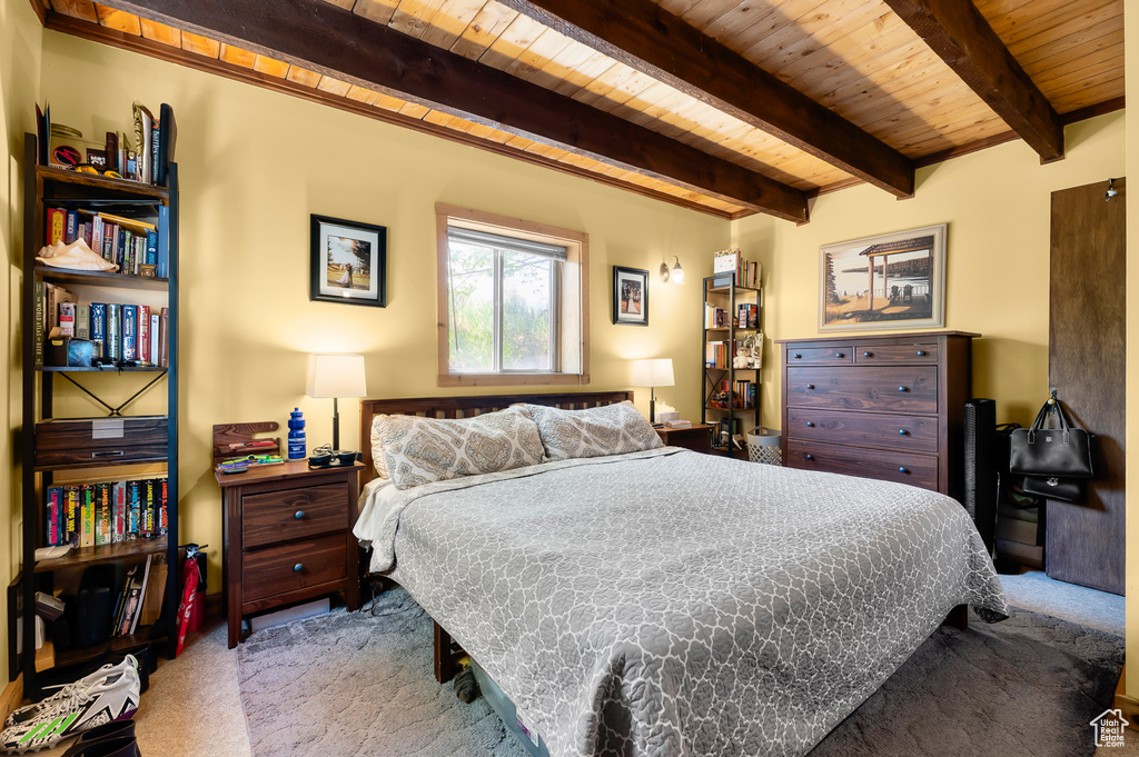 Carpeted bedroom with a wooden ceiling with exposed beams